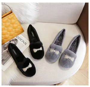 Détail de mocassins d'hiver avec bordure en fourrure synthétique et nœud de perles