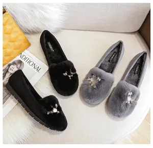 Detailopname van pluche loafers met uil-strass decor en warme voering van imitatiebont