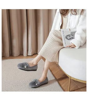 Close-up of grey winter loafers with faux fur pom pom, white pearls and metallic details