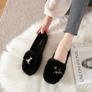 Zwarte pluche loafers met uil strass gesp op een zacht wit kunstbont tapijt