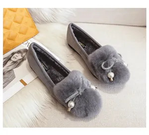 Detail of grey winter fur loafers with rhinestone bow and pearl charm ornament