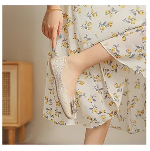 Dettaglio delle scarpe basse beige a punta quadrata con fibbia in strass scintillanti