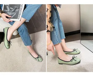 Detail of light green ballet flats with black bow and soft texture on woven carpet