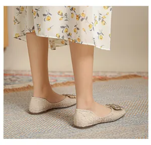 Dettaglio di ballerine beige con pizzo floreale e fibbia quadrata con strass di lusso