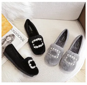 Detalle de mocasines de invierno con ribete de piel sintética y hebillas de perlas y strass