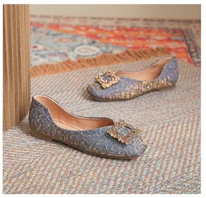 Dettaglio ballerine in jacquard azzurro con trama dorata e fibbia quadrata di strass