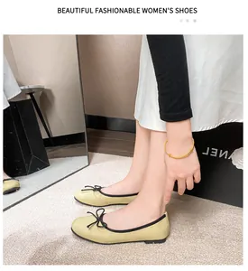 Side view of cream ballet flats with black bow detail and soft sole on a model