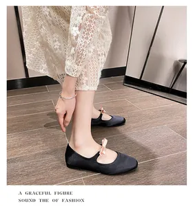 Détail de ballerine Mary Jane en velours noir avec nœud en satin rose et robe en dentelle