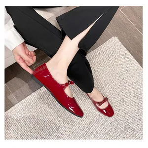 Ballerines Mary Jane en cuir verni rouge avec nœud portées par un mannequin