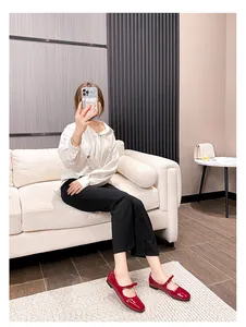 Gros plan de Mary Janes en cuir verni rouge brillant avec nœud et bride sur mannequin