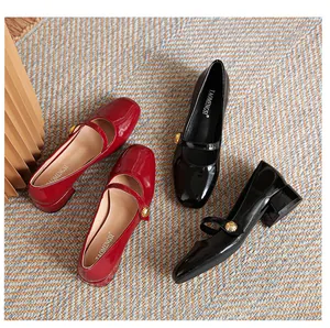 Detail view of glossy patent leather Mary Jane shoes with vintage gold decorative buckles