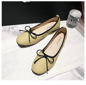 Elegant cream and black bow ballet flats with soft square toe in a stylish setting