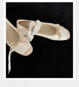 Dettaglio di ballerine bianche a punta quadra con nastri di seta e fiocchi raffinati