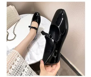 Détail de chaussures Mary Jane en cuir verni noir avec de petits nœuds élégants