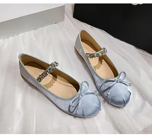 Detail of light blue satin ballet flats with rhinestone Mary Jane strap and bow