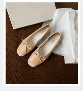 Dettaglio ballerine albicocca crema con fiocco e punta a contrasto su tessuto a maglia