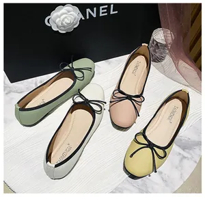 Flat lay of ballet flats in various pastel colors featuring bow tie and pebble grain texture