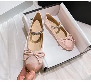 Detailed shot of pink satin Mary Jane ballet flats with rhinestone bow and strap