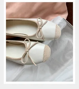 Dettaglio di ballerine beige con punta a contrasto e decorazione a fiocco raffinata