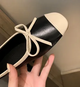 Dettaglio del fiocco elegante su ballerine bicolore con classica punta nera a contrasto