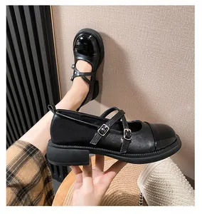Gros plan de chaussures Mary Jane noires à brides croisées et boucles argentées à plateformes