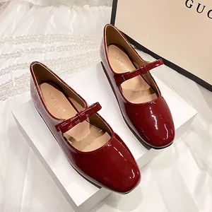 Détail de ballerines Mary Jane en cuir verni bordeaux avec nœud délicat et bout carré élégant