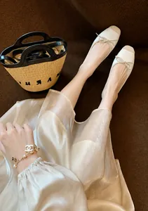 Dettaglio di ballerine a punta quadrata con punta a contrasto e decorazione a fiocco