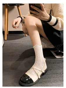 Gros plan de chaussures Mary Jane rétro avec chaussettes en dentelle sur parquet bois