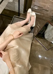 Dettaglio ballerine beige con punta a contrasto e decorazione a fiocco raffinato