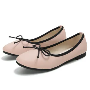 Pink pebbled leather ballet flats with black bow detail and soft soles for women