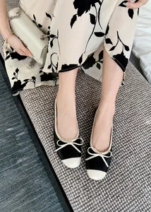 Dettaglio di ballerine bicolore con fiocco e punta a contrasto indossate
