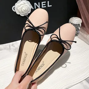 Pink ballet flats with black bow and pebble leather texture for women in soft style