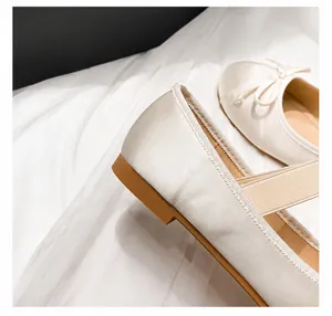 Detail of 1cm comfortable flat heel on cream satin ballet flats with elastic strap