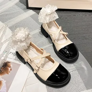 Détail de chaussures Mary Jane crème et noir avec brides croisées et semelle plateforme
