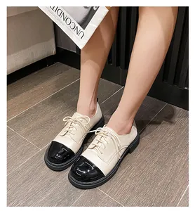 Vue de dessus de mocassins en cuir verni beige et noir avec semelles épaisses sur un modèle