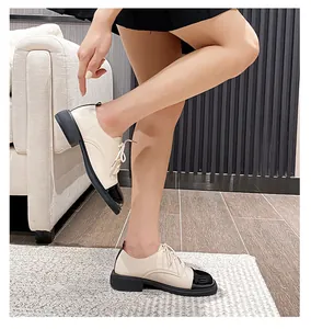 Détail de mocassins à plateforme bicolores en cuir beige et bout en cuir verni noir