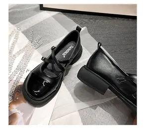 Détail de chaussures Mary Jane rétro noires avec cuir verni et textures mates