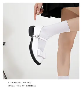 Detailed view of white Mary Jane shoes featuring a large bow and chunky black sole