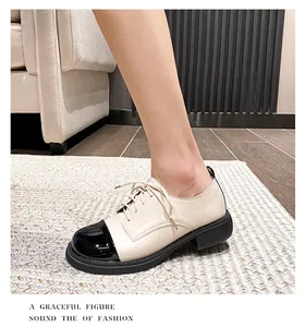 Détail de mocassins bicolores avec bout en cuir verni noir et corps de chaussure beige