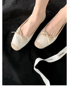 Dettaglio di eleganti ballerine in stile francese con fiocco beige e punta a contrasto