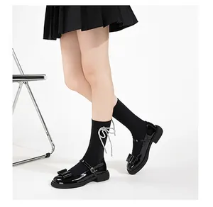 Close-up of glossy black Mary Jane shoes with bow decoration and buckled strap