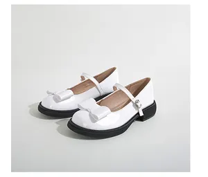 Detailed view of white patent leather Mary Jane shoes with bow and metal buckle strap