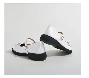 Detailed side view of white patent leather Mary Jane shoes with black platform soles