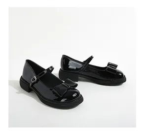 Close-up of black patent leather Mary Jane shoes with bow detail and chunky sole
