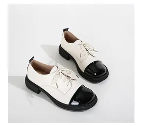 Détails de chaussures richelieu noir et blanc avec bout verni et semelle plateforme