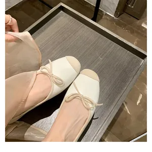 Dettaglio di eleganti ballerine bicolore con fiocco e punta squadrata dal design chic