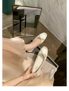 Dettaglio di eleganti ballerine bicolore con fiocco e trama in pelle di alta qualità