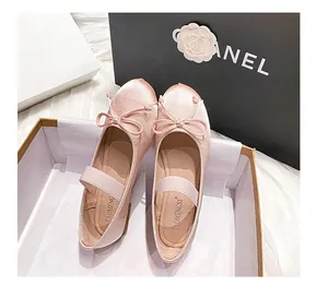 Detalle de bailarinas Mary Jane de satén rosa con lazo y correa elástica