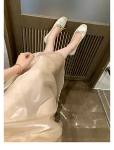 Dettaglio di ballerine con fiocco e design bicolore indossate con stile elegante