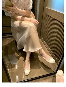 Dettaglio di ballerine beige con fiocco, punta a contrasto e design elegante stile francese